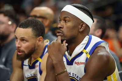 Jimmy Butler III #10 and Stephen Curry #30 of the Golden State Warriors watch from the bench during the second half of the NBA game against the Phoenix Suns at PHX Arena 
